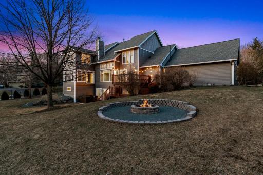 The fully fenced backyard features extensive landscaping, trees, plants, shrubs, arborvitaes, a large paver patio, retaining walls to improve land function and a firepit.