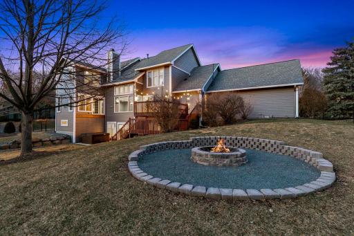 The fully fenced backyard features extensive landscaping, trees, plants, shrubs, arborvitaes, a large paver patio, retaining walls to improve land function and a firepit.