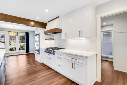 The fully remodeled chefâs kitchen features custom cabinets, quartz tops, a massive island, double ovens, a 6-burner Thermador cooktop, a custom fanhood, a 32-cubic-foot refrigerator, under cabinet lighting, a pantry in the mudroom, and more.