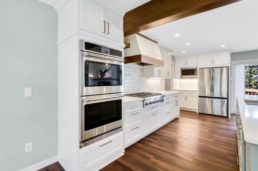The fully remodeled chefâs kitchen features custom cabinets, quartz tops, a massive island, double ovens, a 6-burner Thermador cooktop, a custom fanhood, a 32-cubic-foot refrigerator, under cabinet lighting, a pantry in the mudroom, and more.