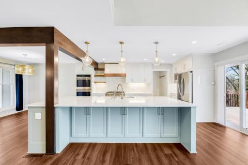 The fully remodeled chefâs kitchen features custom cabinets, quartz tops, a massive island, double ovens, a 6-burner Thermador cooktop, a custom fanhood, a 32-cubic-foot refrigerator, under cabinet lighting, a pantry in the mudroom, and more.