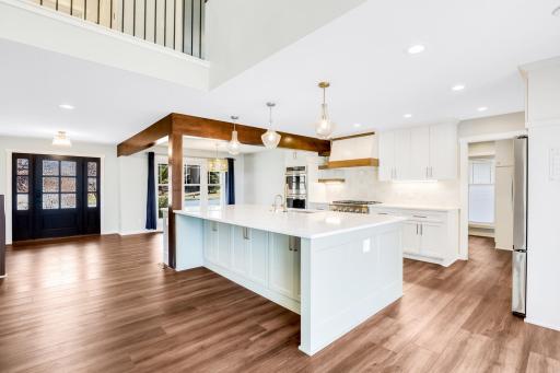 The fully remodeled chefâs kitchen features custom cabinets, quartz tops, a massive island, double ovens, a 6-burner Thermador cooktop, a custom fanhood, a 32-cubic-foot refrigerator, under cabinet lighting, a pantry in the mudroom, and more.