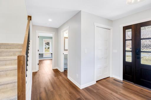 The hallway from the main foyer leads to the main-floor half bath and office.
