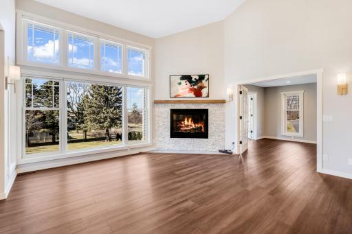 The living room features a gas fireplace, and a wall of SW Facing windows that overlook the private backyard with views of the Mississippi River Valley.