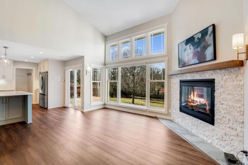The living room features a gas fireplace, and a wall of SW Facing windows that overlook the private backyard with views of the Mississippi River Valley.