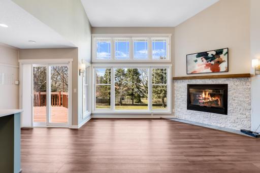 The living room features a gas fireplace, and a wall of SW Facing windows that overlook the private backyard with views of the Mississippi River Valley.