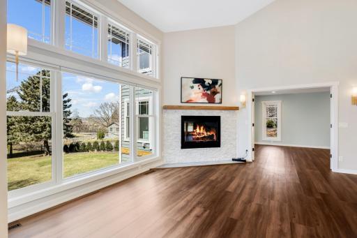 The living room features a gas fireplace, and a wall of SW Facing windows that overlook the private backyard with views of the Mississippi River Valley.
