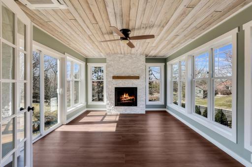 The sunroom is surrounded by windows, features a gas fireplace, and a glass door for a future deck expansion.