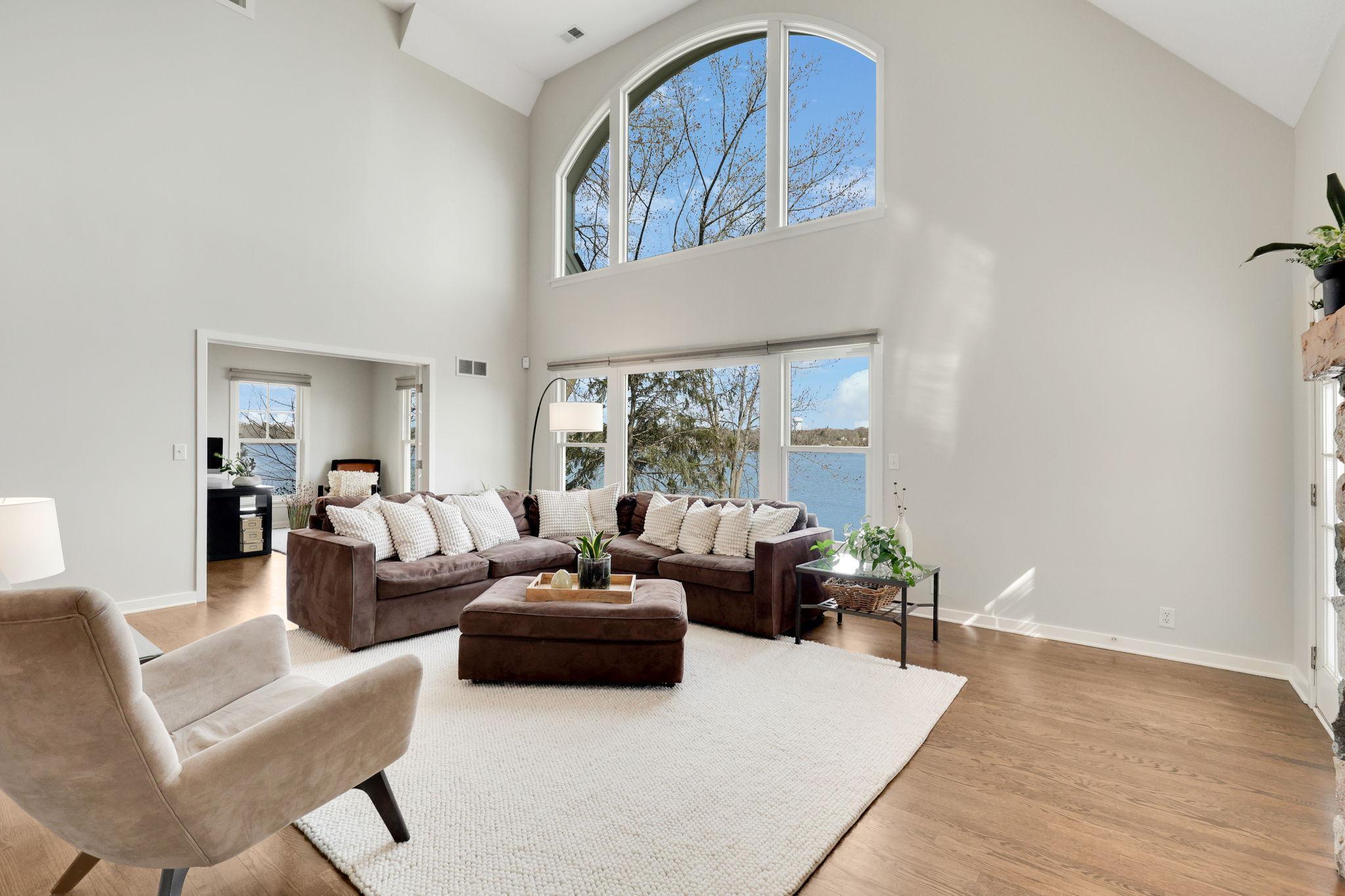 2 story great room with a wall of windows to the lake