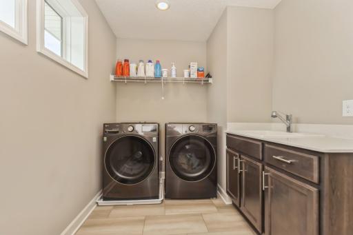 Convenient upper level laundry with sink and extra storage.