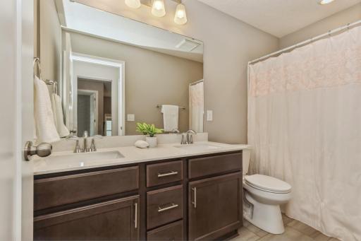 Upper level full bath with double sink vanity.