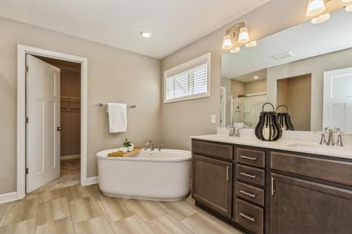 Gorgeous spa-like primary bath with stand-alone soaking tub, walk-in closet and double sink vanity.