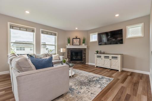 Inviting main floor living room with cozy fireplace, recessed lighting and transom windows.