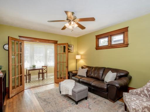 Main level living area opens to a cozy front sunroom through classic French doors.
