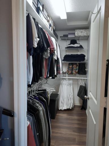 Primary walk in closet with custom shelves