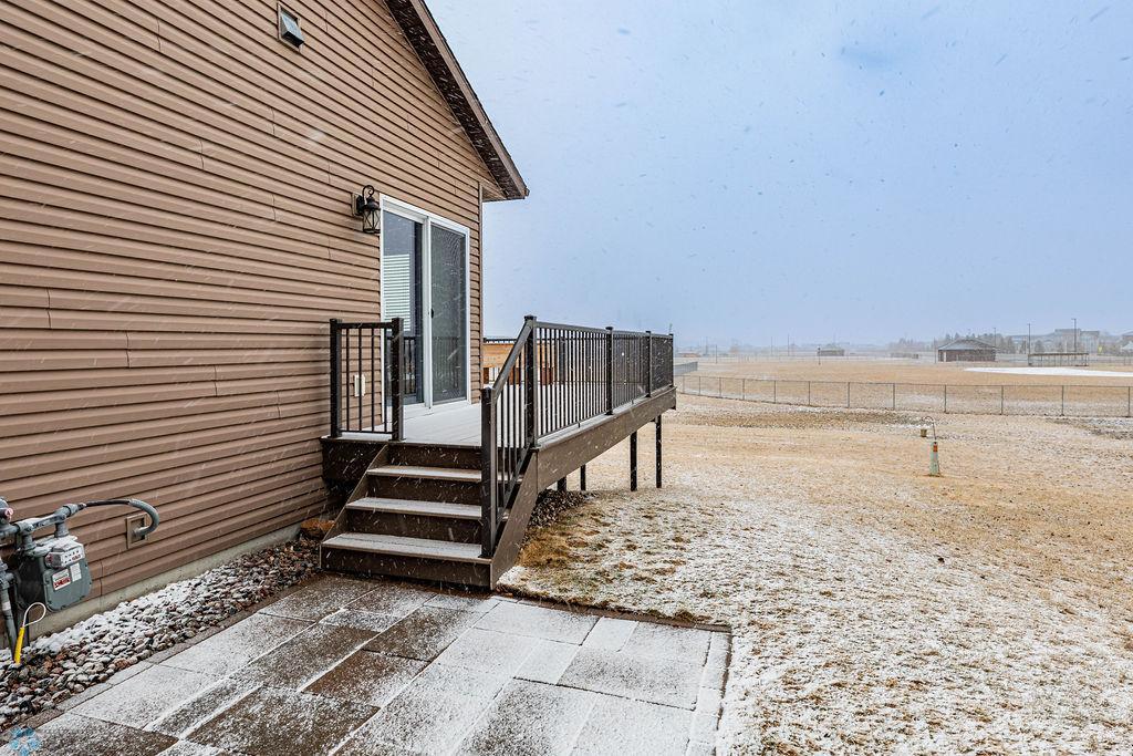 Patio from back of garage leads onto deck with entry to dining area