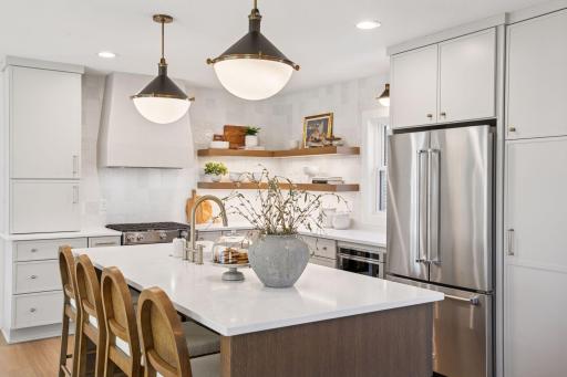 designer kitchen with a large quartz island & custom cabinetry.