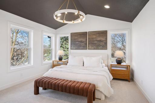 The primary suite is a true retreat, complete with vaulted ceilings, beautiful natural light, and spa-like style.