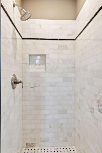 The guest en-suite shower features tasteful tile-work on all three walls and the floor.