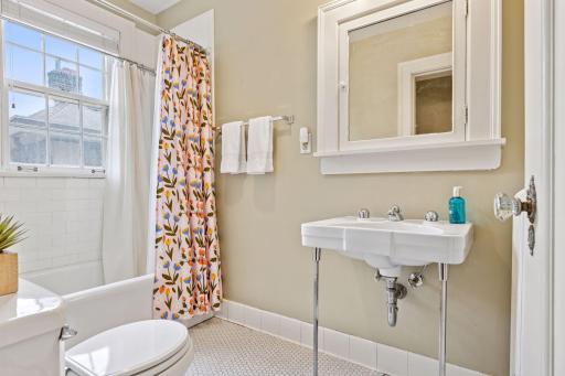 The third bathroom on the second level has a full bath tub and tile flooring.