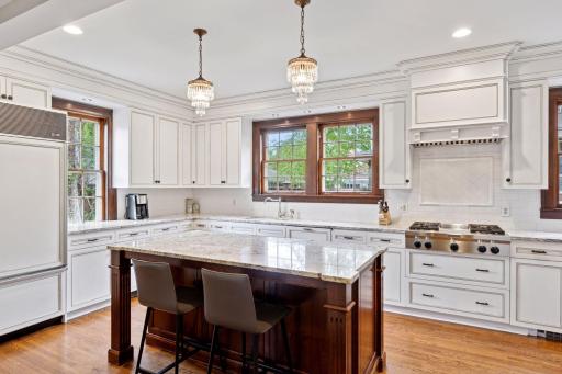 Updated kitchen is a chefâs dream- featuring antique white shaker style cabinets with elegant crown molding, granite countertops, Sub-Zero refrigerator, new dishwasher, gas cooktop, double oven and neutral tile backslash.