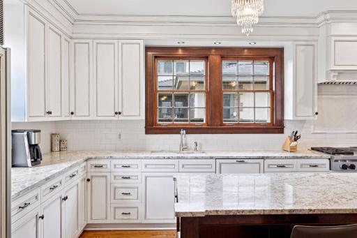 The kitchen is framed by elegant cabinetry and enhanced with thoughtfully curated finishes.