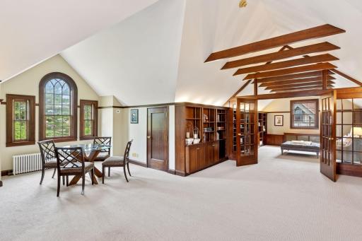 Natural light floods the attic space through thoughtfully grouped windows- arranged in pairs and triosâenhancing the airy atmosphere and drawing attention to the fine details throughout.