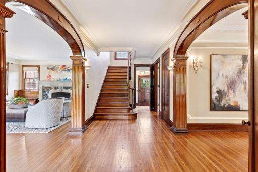Rich wood trim defines this interior. Features include arched doorways with detailed columns, intricate crown molding, thick baseboards, and a solid wood staircase with matching treads, risers, balustrade, and newel post!