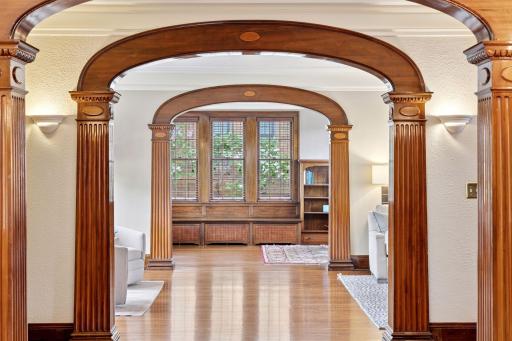 The interior's main level flows seamlessly from room to room, showcasing stunning grand wood archways, supported by fluted columns with detailed capitals, creating an undeniable "wow factor."