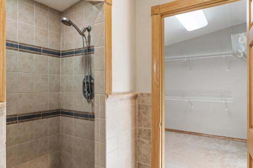 Primary bathroom featuring dual sinks, a tile shower, and a soaking tub.