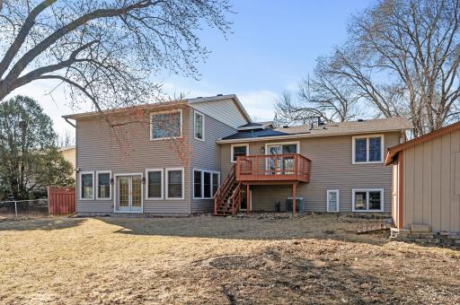 Spacious fenced in backyard with a fire pit and shed.
