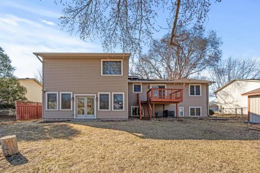 Spacious fenced in backyard with a fire pit and shed.