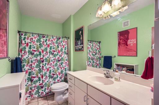 A cheerful, spacious bath with tub and shower. A large vanity with plenty of counter space.