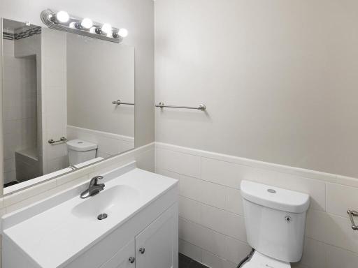 The upper level 3/4 bath features a classic brand new single storage white vanity, tiled wall and floors.