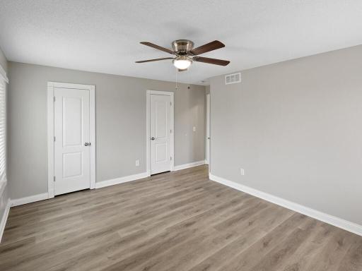 The primary bedroom features clean white trim and easy-maintenance flooring, creating a bright and welcoming atmosphere.
