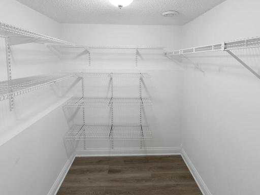 This walk-in closet has a thoughtfully designed storage system to keep everything neatly arranged and organized.