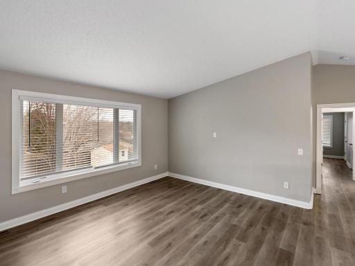 The living room offers views of the backyard and features crisp white trim, timeless grey walls and durable, easy-to-maintain flooring.