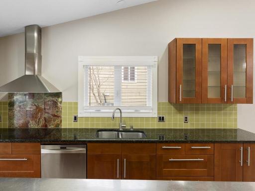With its contemporary cabinetry, granite countertops, stainless steel island and eye catching glass tile backsplash, this kitchen is both inviting and efficient.