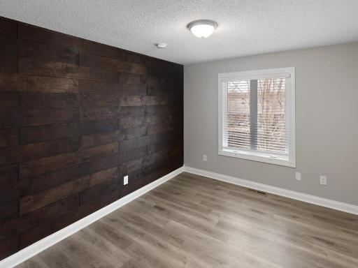 A wood-accent wall enhances the upper level bedroom's charm.