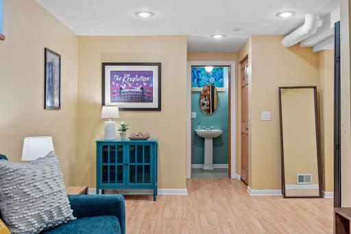The basement hallway leads to a stylish Â¾ bath, framed by cheerful tones and modern finishesâperfect for use as part of a private primary suite, enhancing both comfort and livability.