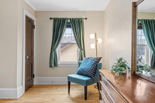 Tucked into a quiet corner of the primary bedroom, this cozy sitting area is perfect for reading or relaxing, with warm tones, a pop of color, and natural window light.