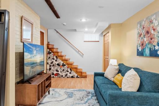 The lower-level family room highlights custom stair risers and an open layoutâblending charm, comfort, and a distinctive design element that sets the space apart.