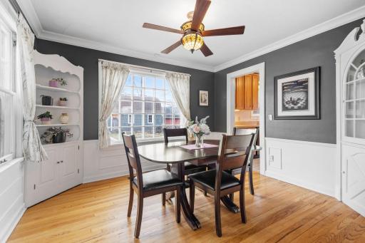 The formal dining room is full of character, featuring wainscoting, a built-in corner hutch, and a large window that fills the space with sunlightâperfect for hosting gatherings.