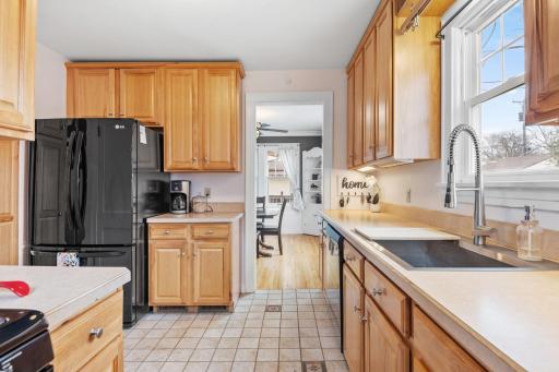 The kitchen opens gracefully into the dining room, offering ceramic tile flooring, warm wood cabinetry, and modern black appliancesâperfect for effortless everyday living.