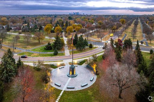 Victory Memorial Drive shines at sunset with its iconic flagpole monument, peaceful greenery, and views stretching toward the Minneapolis skyline.