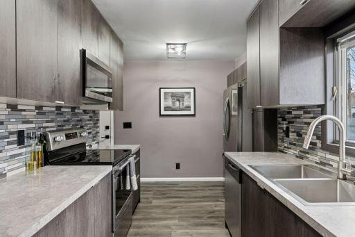 Fully remodeled kitchen with tile backspash and stainless steel appliances