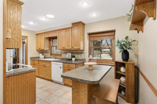 Great kitchen with full tile backsplash, matching appliances, shaker style cabinets, and tile floors