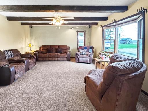 Large living room boasting natural light and wood beams