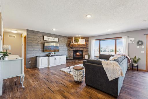 Another view of the main level living room. Note the cozy gas fireplace! Love the pretty stone and cool beam. This room is amazing and may be one of your favorite places to hang out with family and friends!