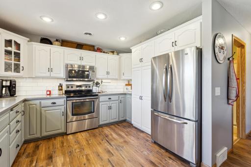 Love the white upper cabinetry with the warm colored lower cabinetry! So fun! Wonderful stainless steel appliances and loads of storage too!